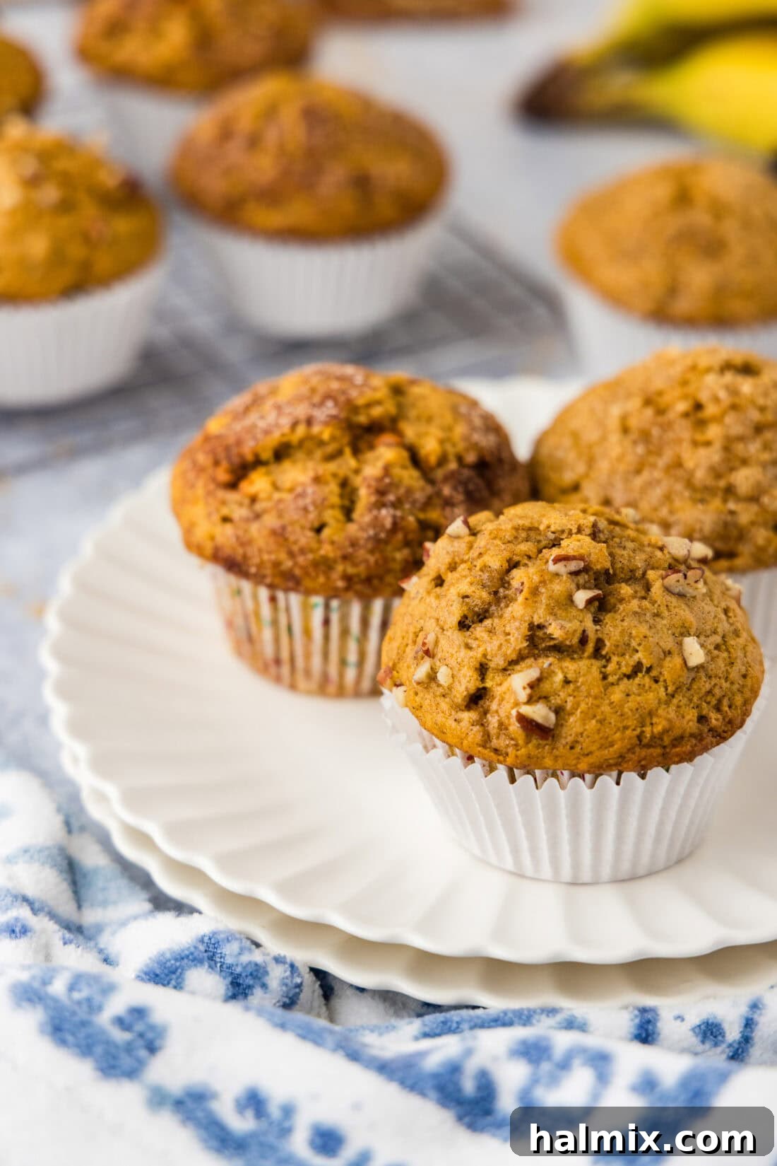 Three Pumpkin Banana Muffins on a wire rack with various toppings.