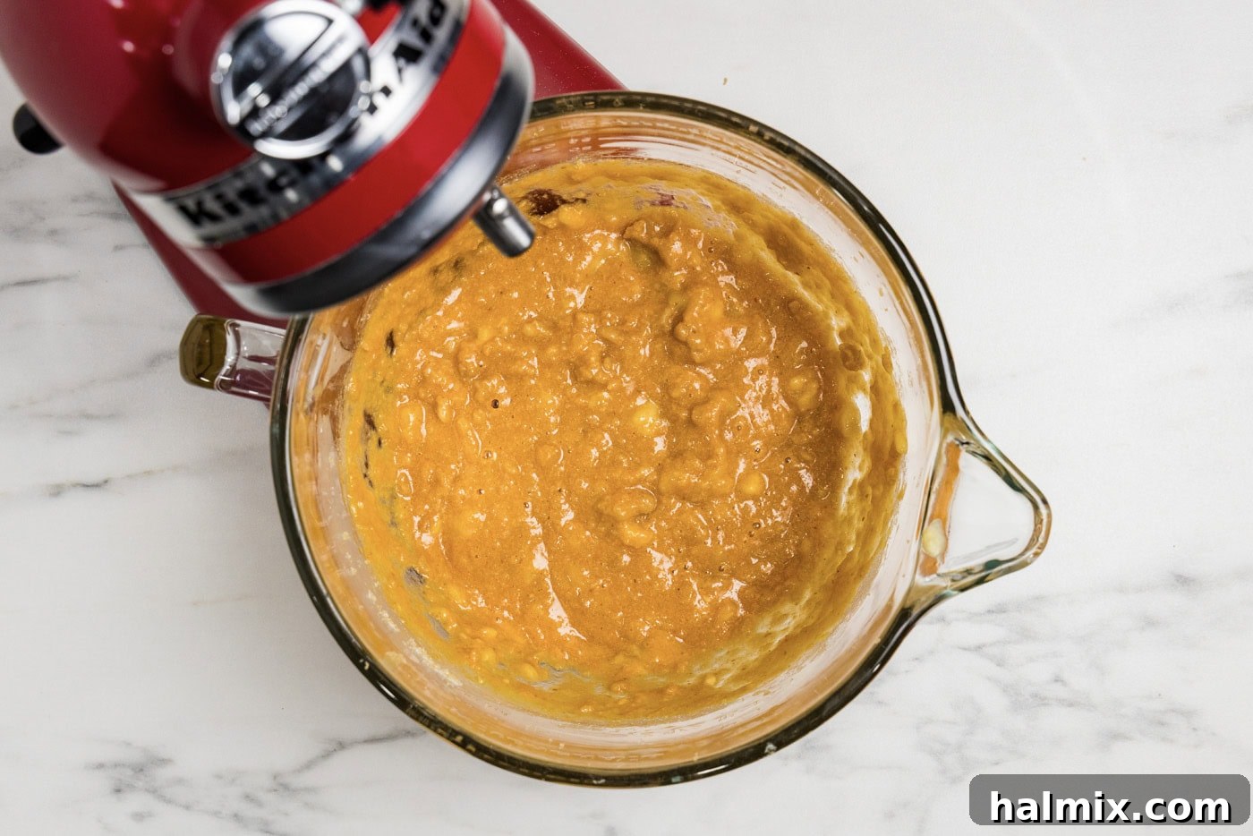 Pumpkin, spices, and butter mixture in a stand mixer bowl.