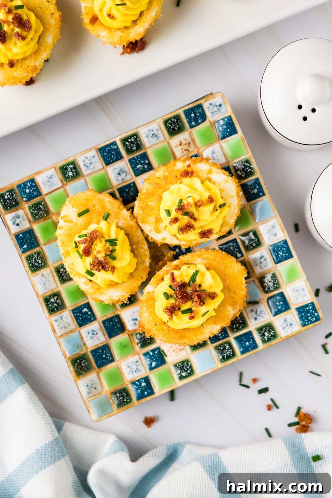 Three Fried Deviled Eggs on a square plate