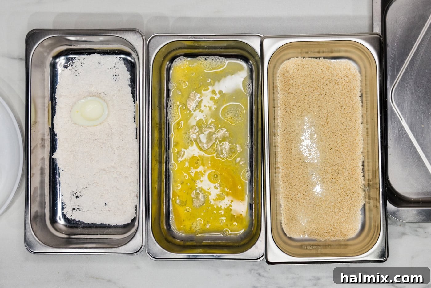 boiled egg in flour inside a breading tray