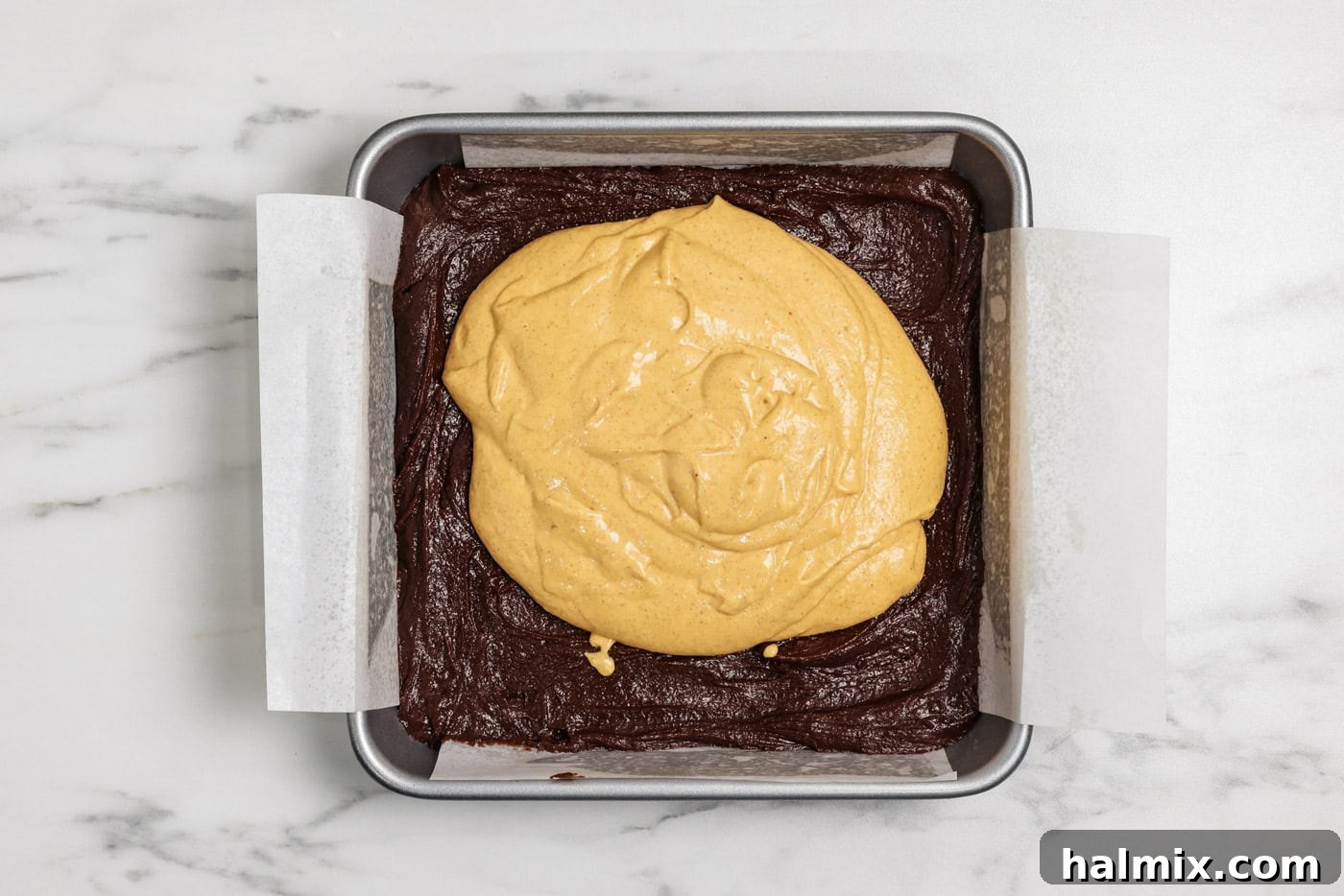Spiced Pumpkin Swirl Brownies 12 pumpkin cheesecake batter on top of brownie batter in a baking pan