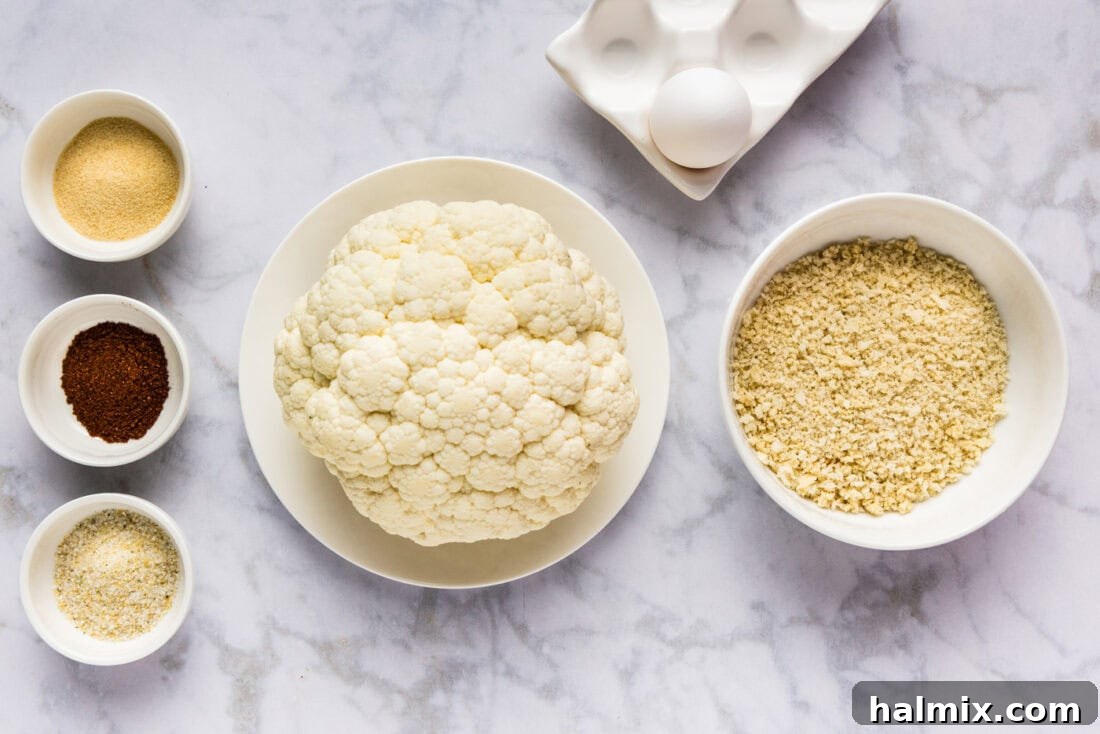 Perfectly Crispy Air Fryer Cauliflower 4 Arrangement of fresh cauliflower, panko breadcrumbs, various spices, egg, and water on a kitchen counter, ready for air frying.