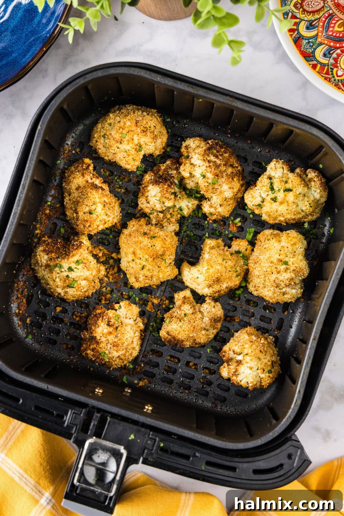 Perfectly Crispy Air Fryer Cauliflower 10 A close-up shot of a full air fryer basket filled with perfectly golden and crispy Air Fryer Fried Cauliflower, ready to serve.