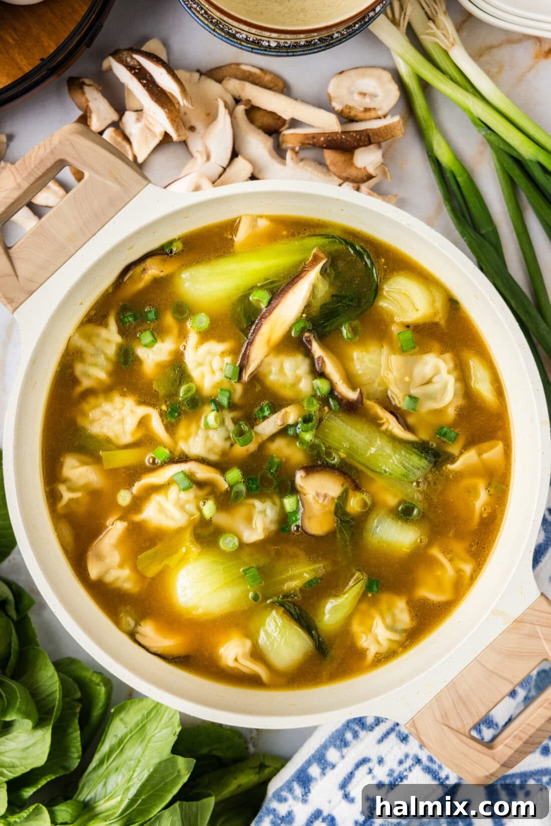 Bowl of Wonton Soup with fresh vegetables around it, looking vibrant and appealing.