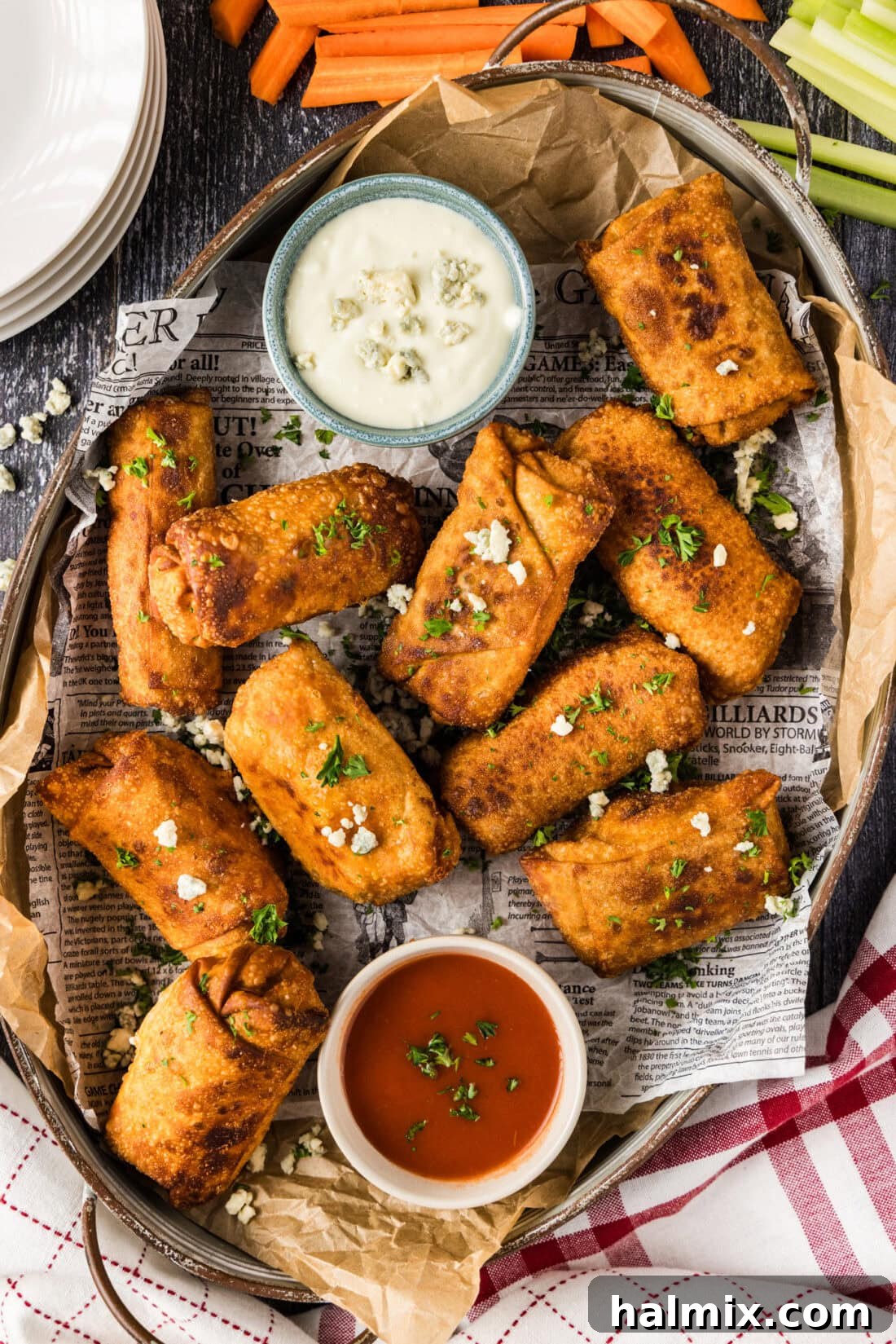 Platter of Buffalo Chicken Egg Rolls with bowls of blue cheese dressing and buffalo sauce