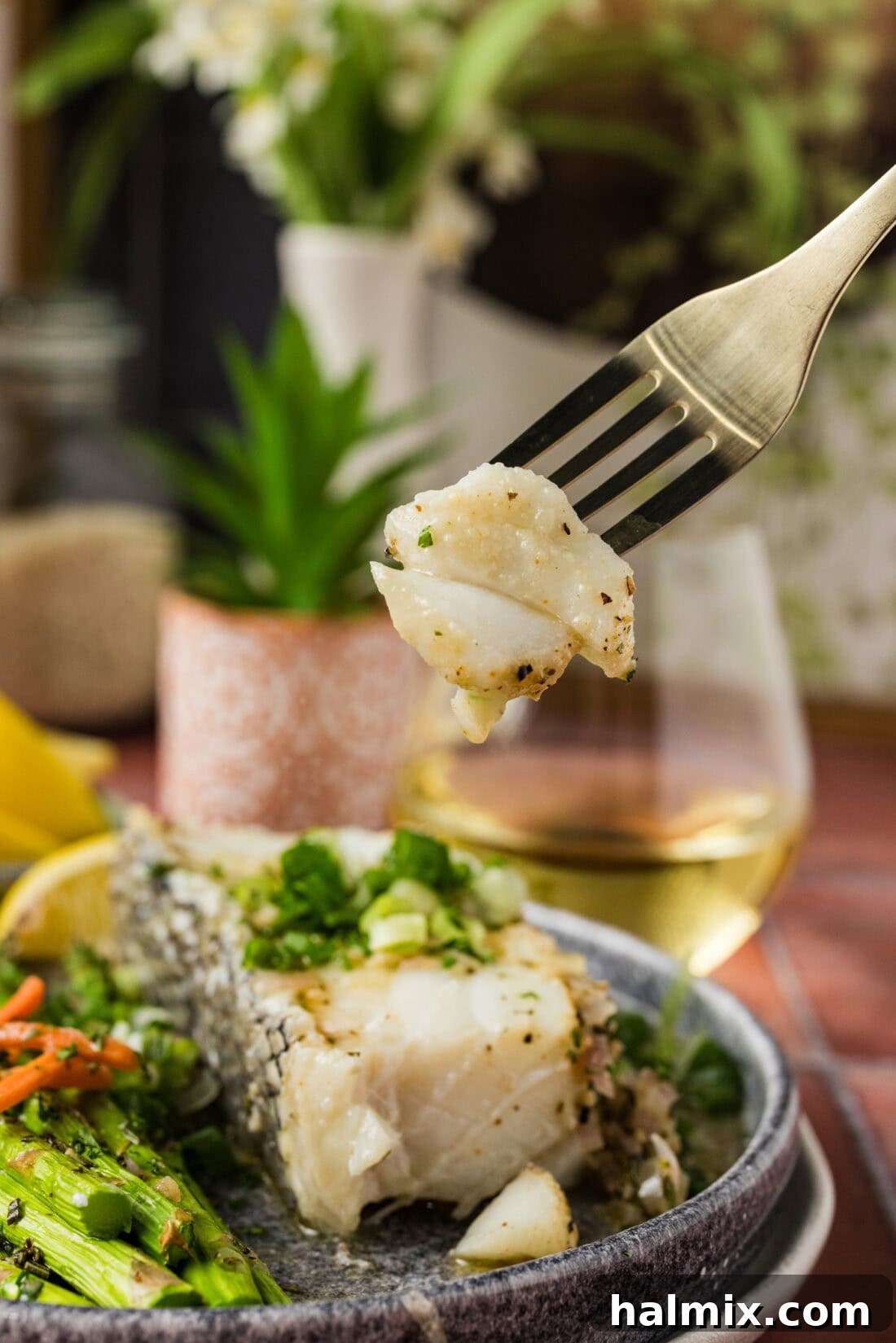 Close-up of a piece of perfectly cooked Steamed Chilean Sea Bass on a fork