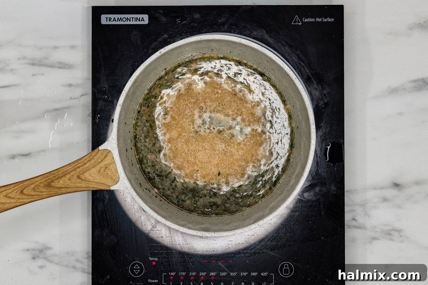 The savory white wine sauce simmering gently in a pot on the stovetop