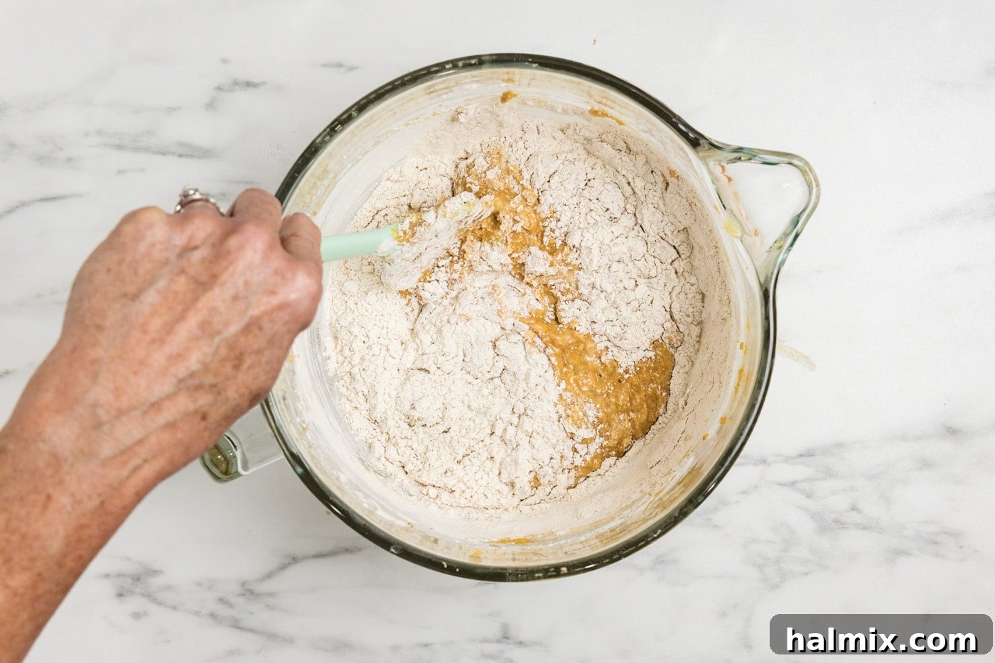 folding the rest of the flour into pumpkin batter with a rubber spatula