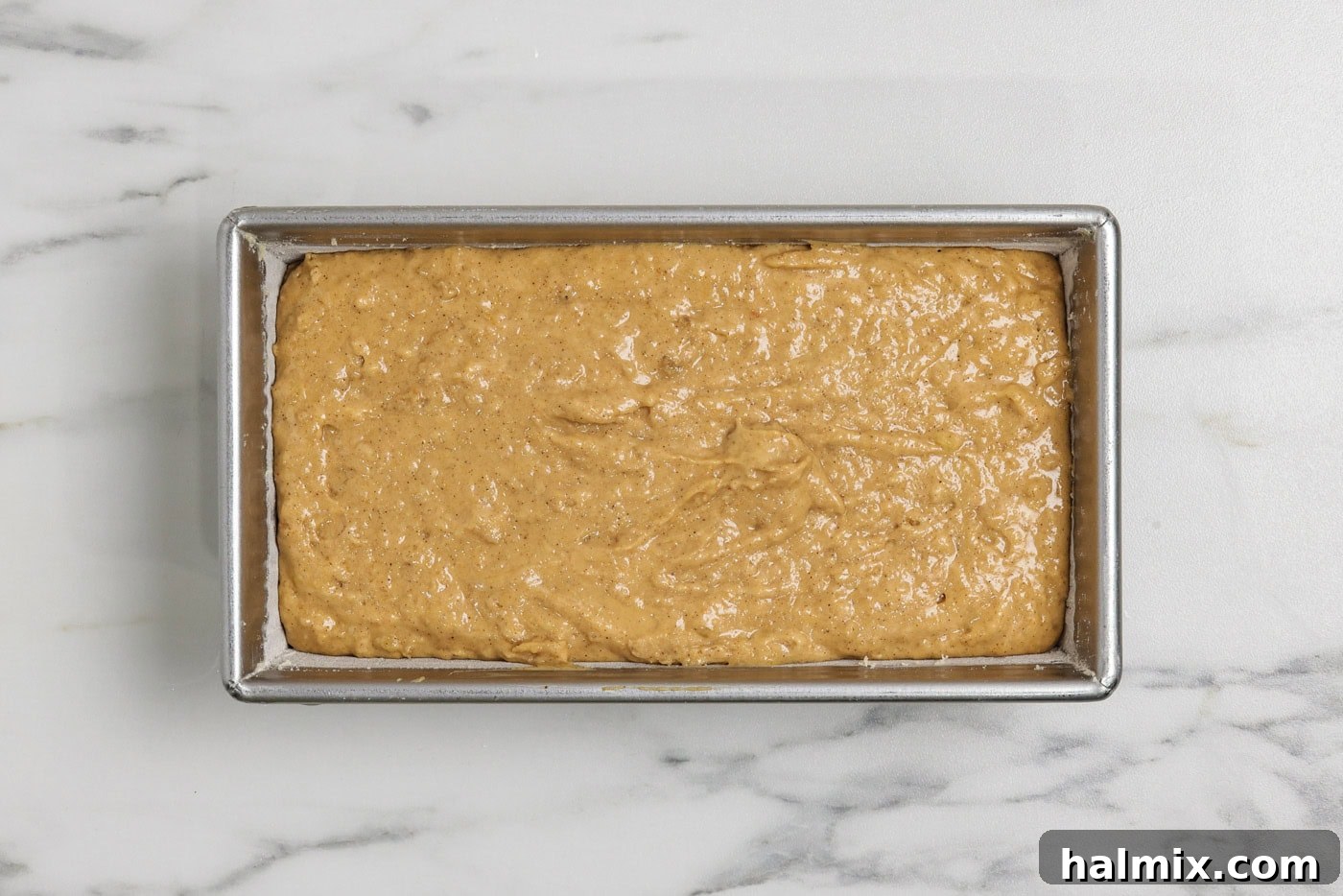pumpkin banana bread batter in a floured loaf pan