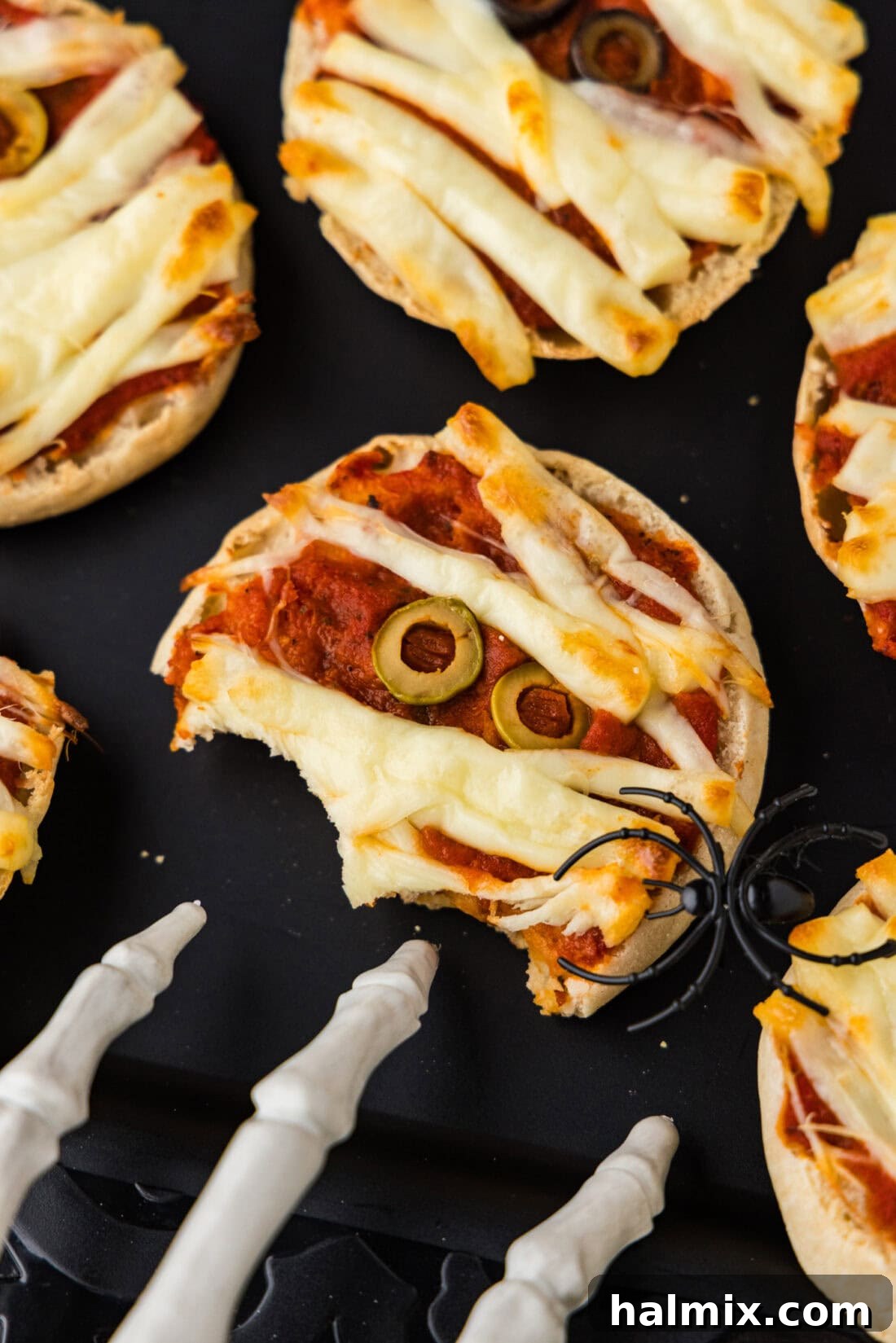 Half eaten Mini Mummy Pizza on a black platter