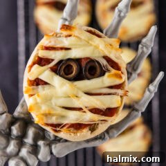 Close up photo of a Mini Mummy Pizza in a skeleton hand