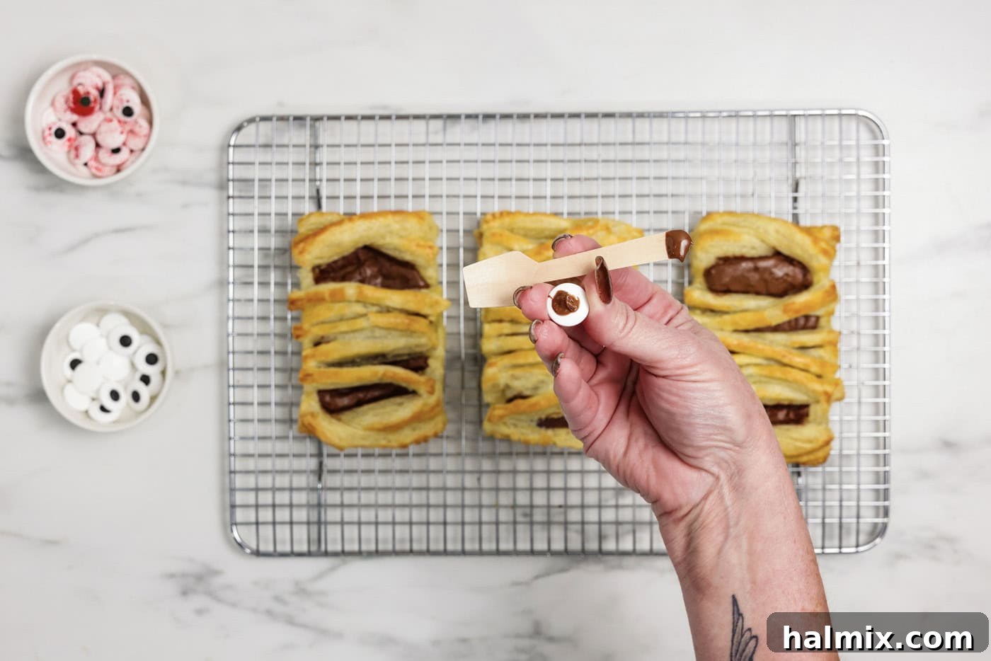 The back of a candy eyeball with a small amount of Nutella, ready to be placed on a hand pie