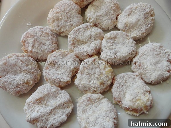 A close-up view of several raw, double-breaded chicken nuggets, perfectly shaped and flattened, ready to be fried to golden perfection.