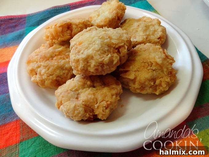 Another close-up overhead photo of homemade chicken nuggets artfully arranged on a clean white plate, highlighting their golden crust.