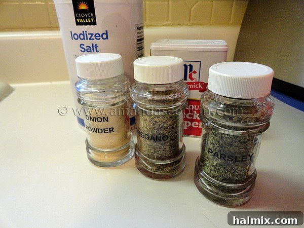 Small glass jars containing essential dried spices: onion powder, dried oregano, and dried parsley flakes.