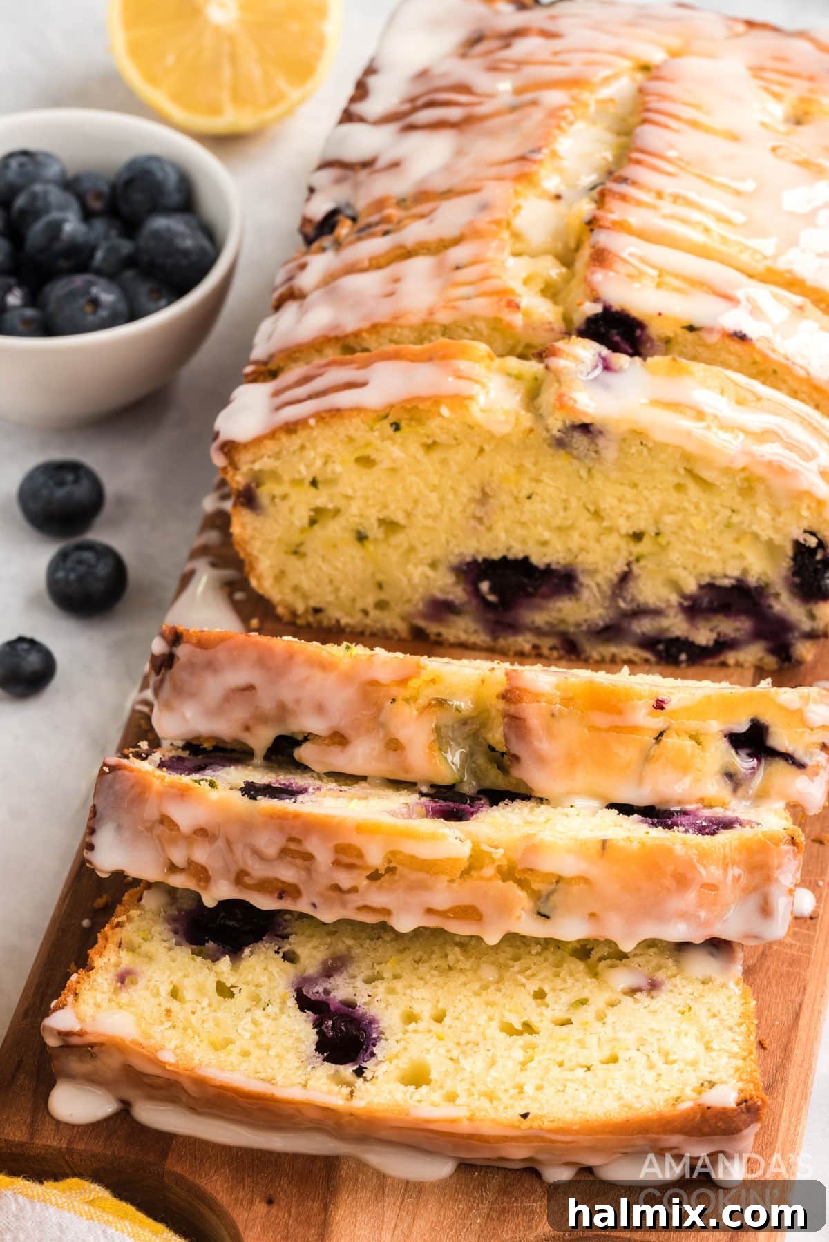 close up of sliced lemon blueberry zucchini bread with a vibrant lemon glaze