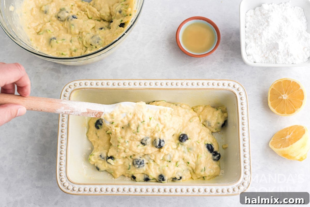 transferring the lemon blueberry zucchini bread batter into the prepared loaf pan