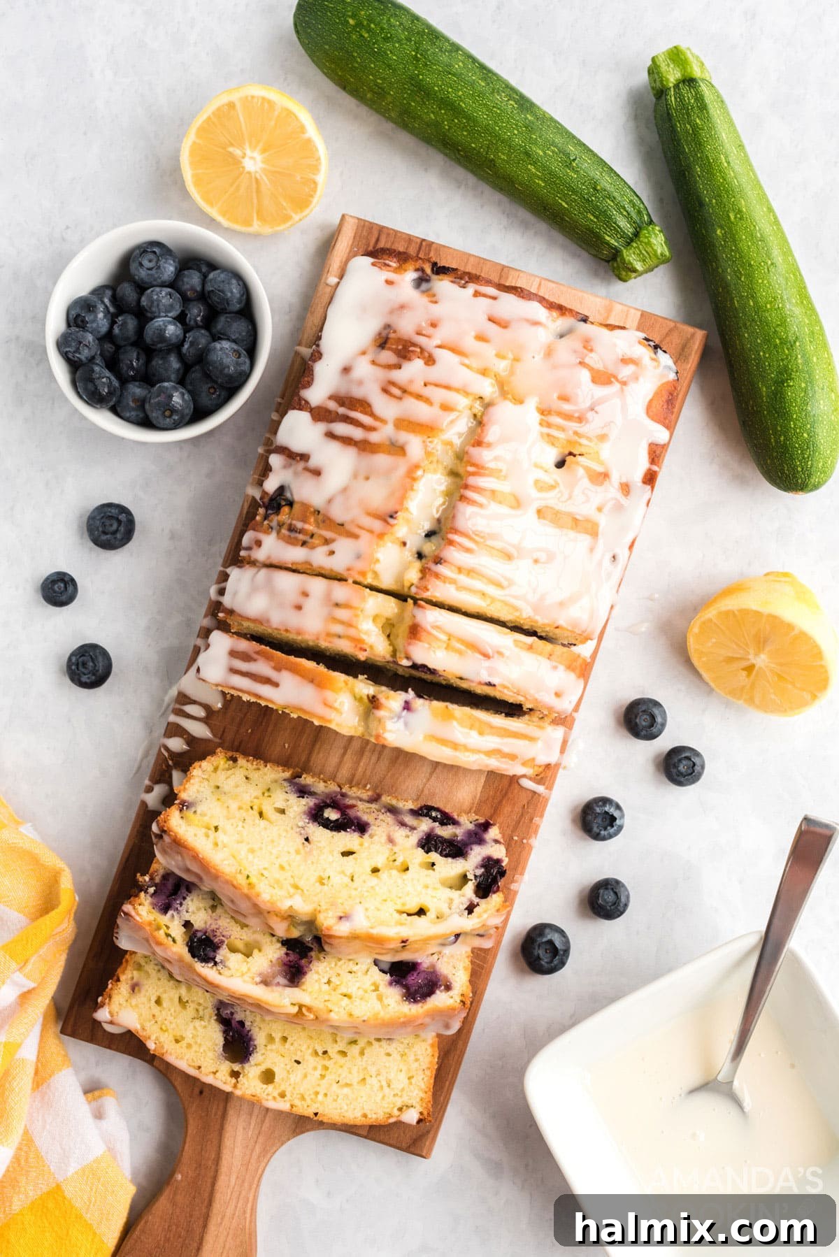 overhead photo of sliced lemon blueberry zucchini bread on a cutting board, revealing the texture and blueberries