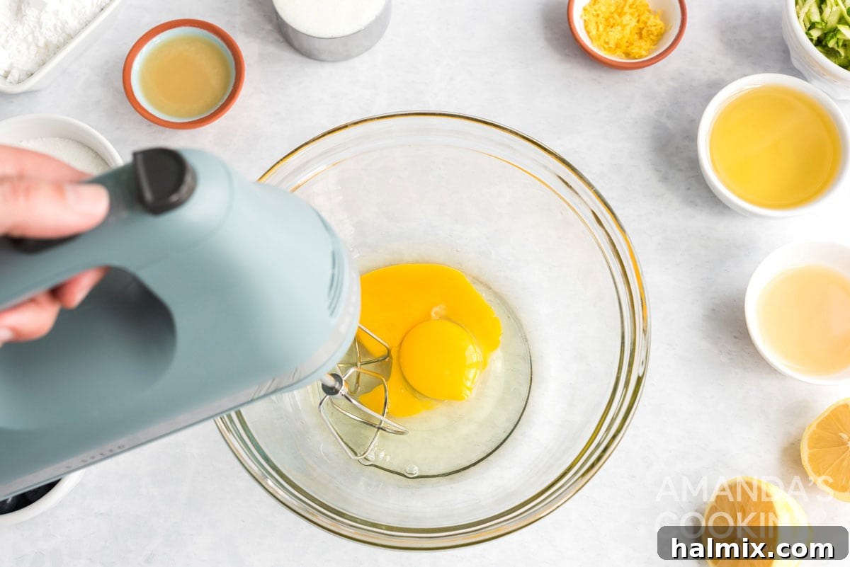 eggs being beaten in a bowl with an electric mixer until light yellow