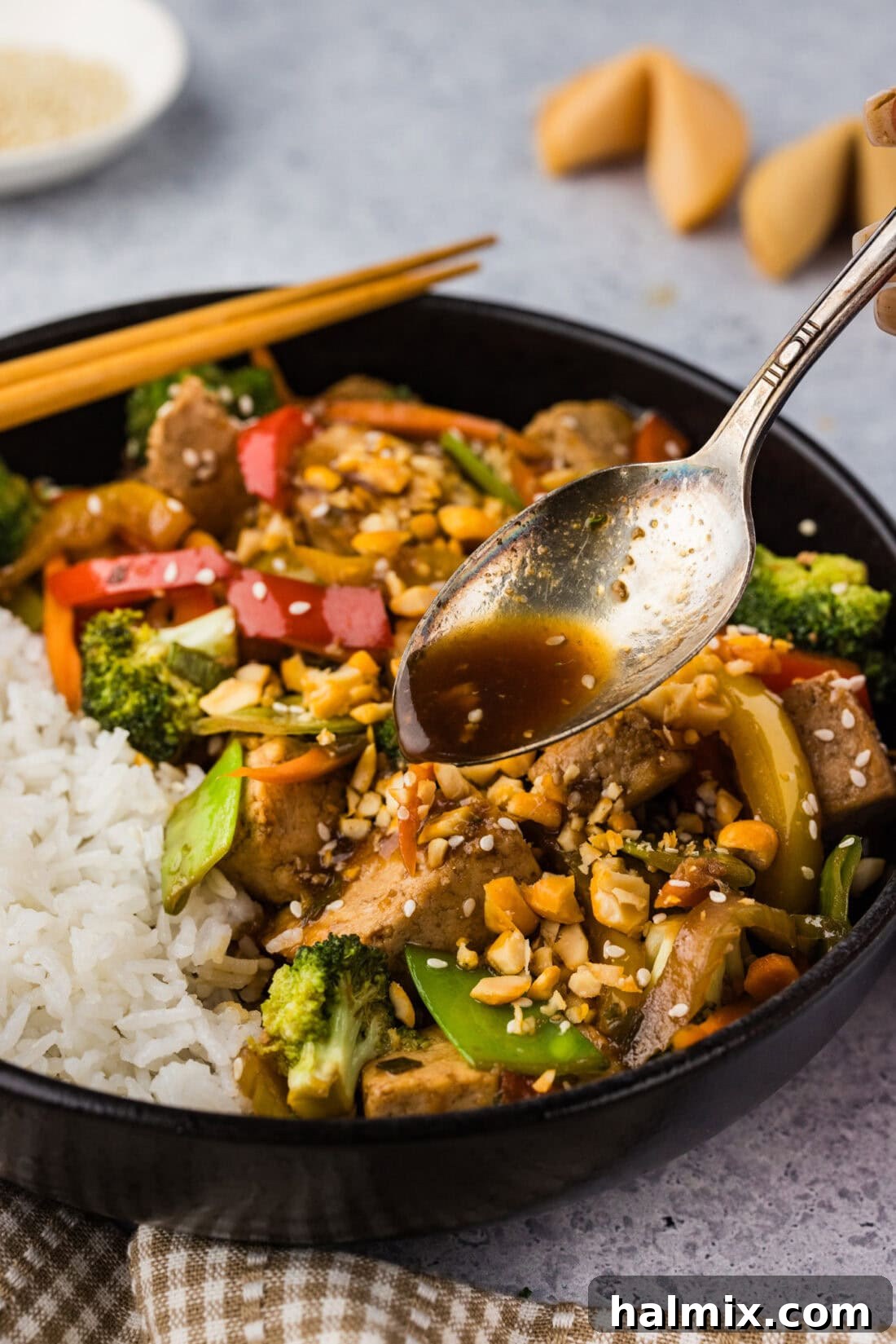 Golden Tofu Stir-Fry 10 Spoon drizzling sauce over Tofu Stir Fry, making it glisten and look appealing.