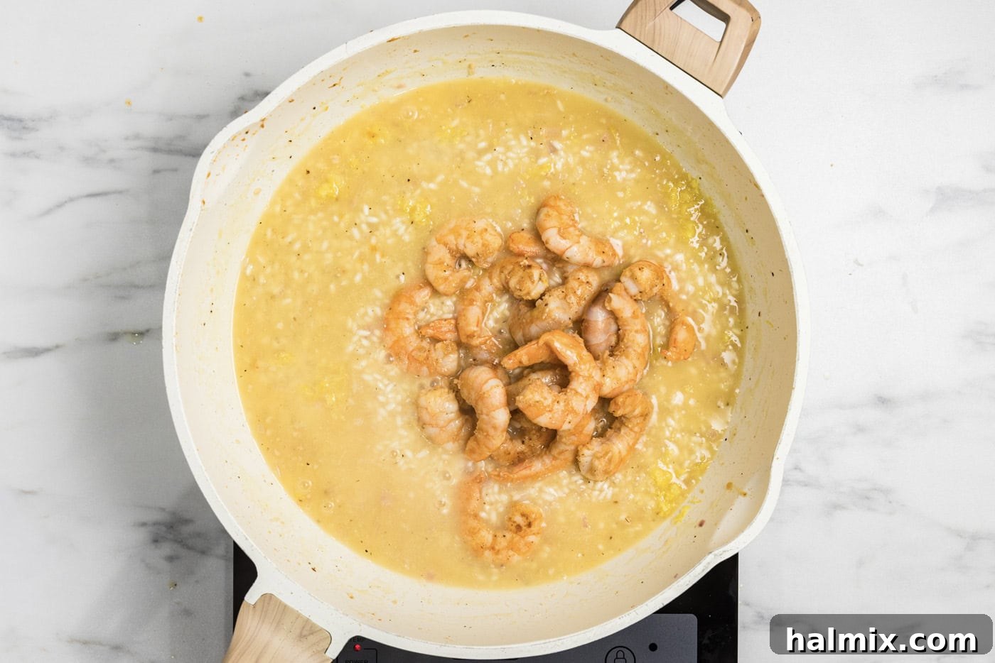 Creamy Prawn Risotto 10 Partially cooked shrimp being returned to the skillet with the creamy risotto mixture.