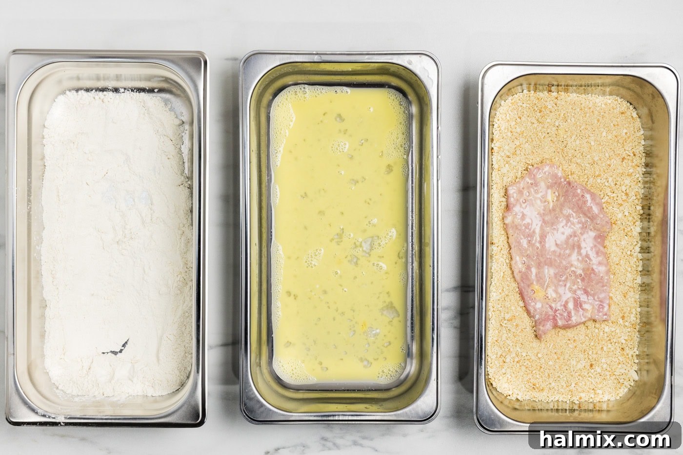 dredged veal cutlet in breading tray with panko bread crumbs