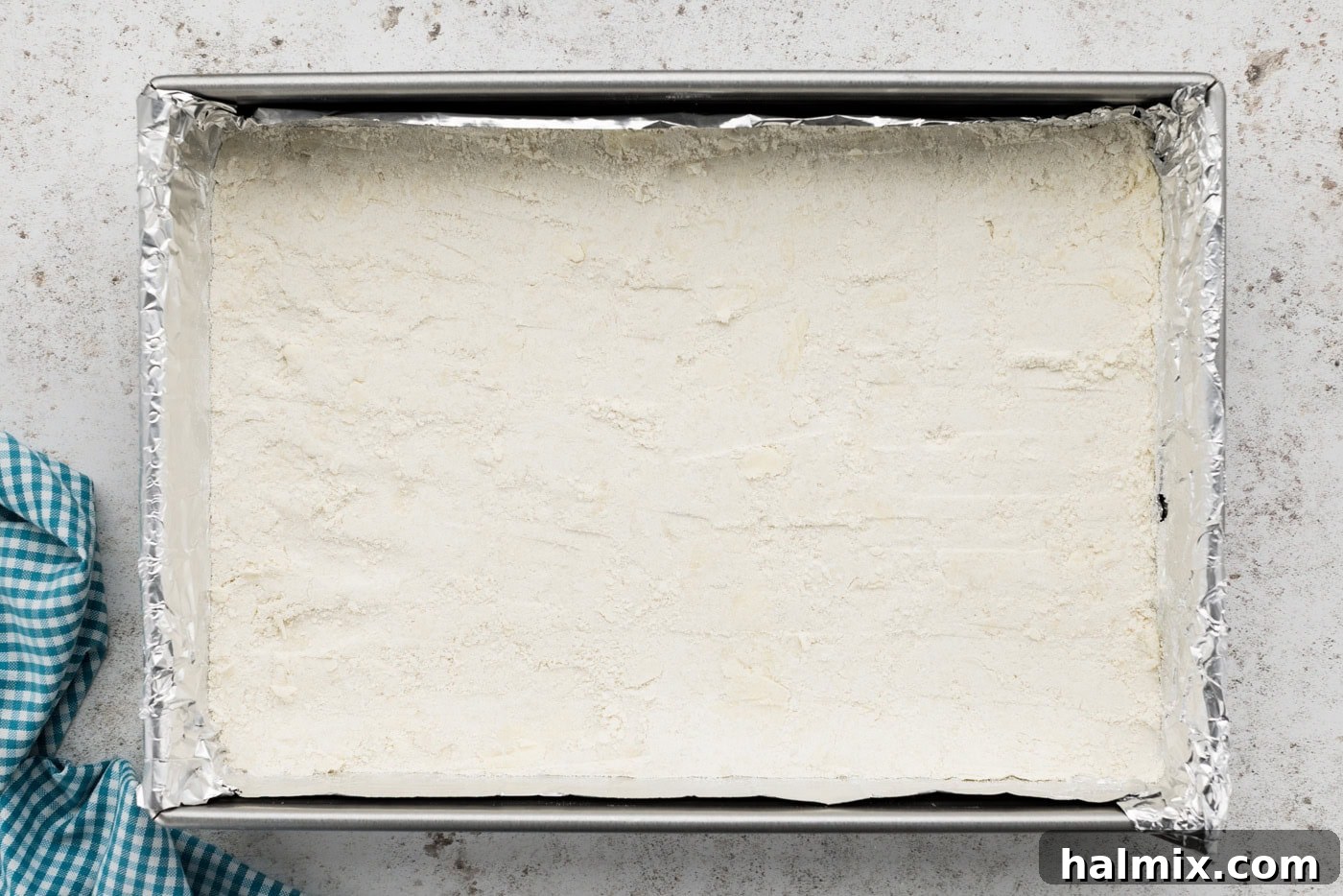 Decadent Pecan Pie Squares 6 Shortbread crust pressed evenly on the bottom of a baking dish, ready for baking.