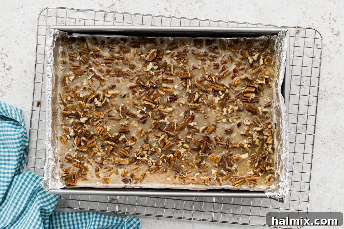 Decadent Pecan Pie Squares 9 Pecan pie filling added to a baking dish on top of the shortbread crust, ready for the oven.