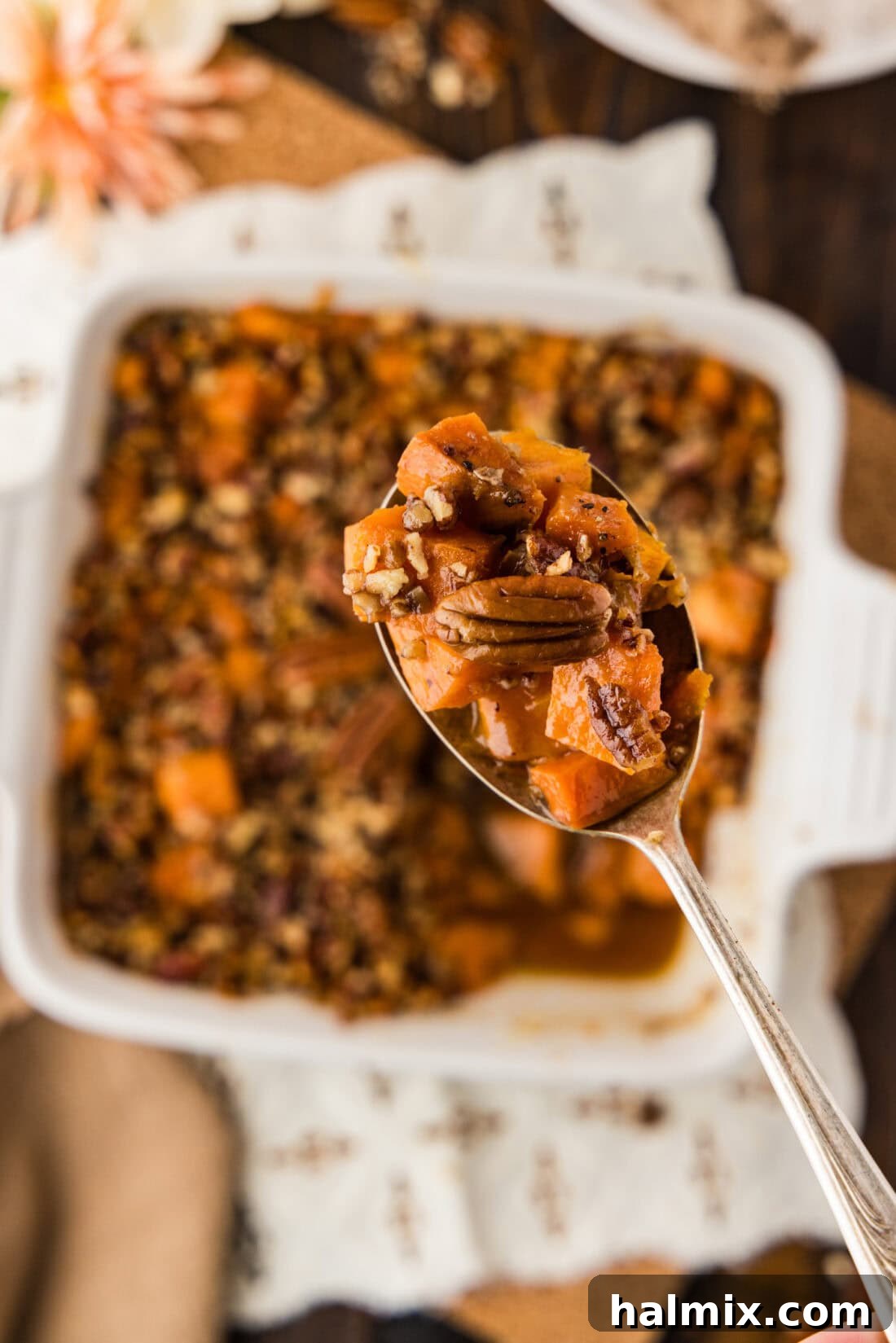 Bourbon Glazed Sweet Potatoes 12 Spoonful of Kentucky Bourbon Sweet Potatoes held above a baking dish of Kentucky Bourbon Sweet Potatoes
