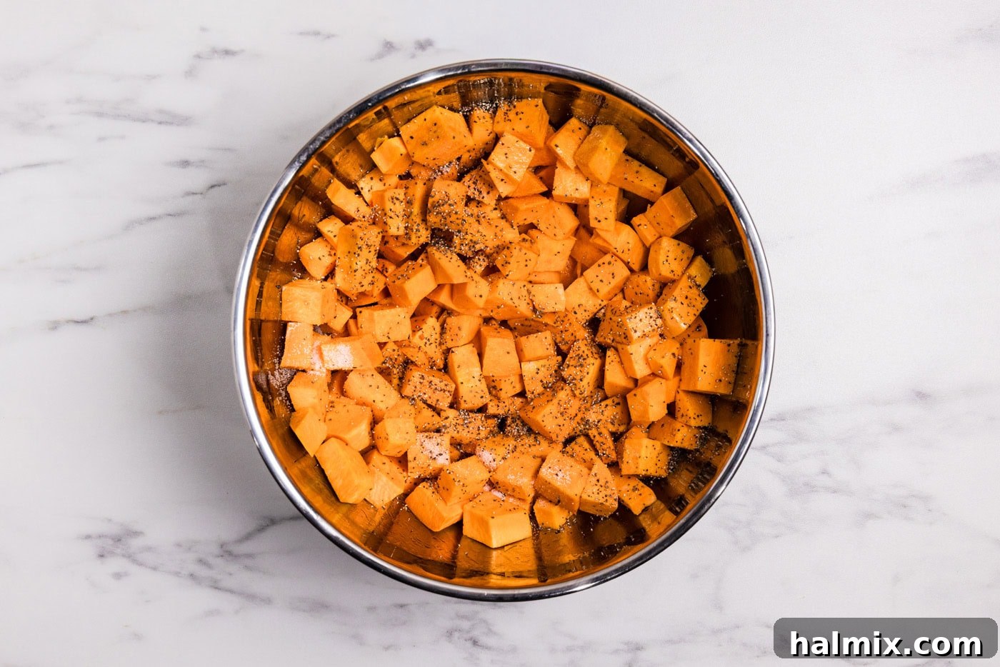 Bourbon Glazed Sweet Potatoes 5 cubed sweet potatoes in a bowl with salt and pepper