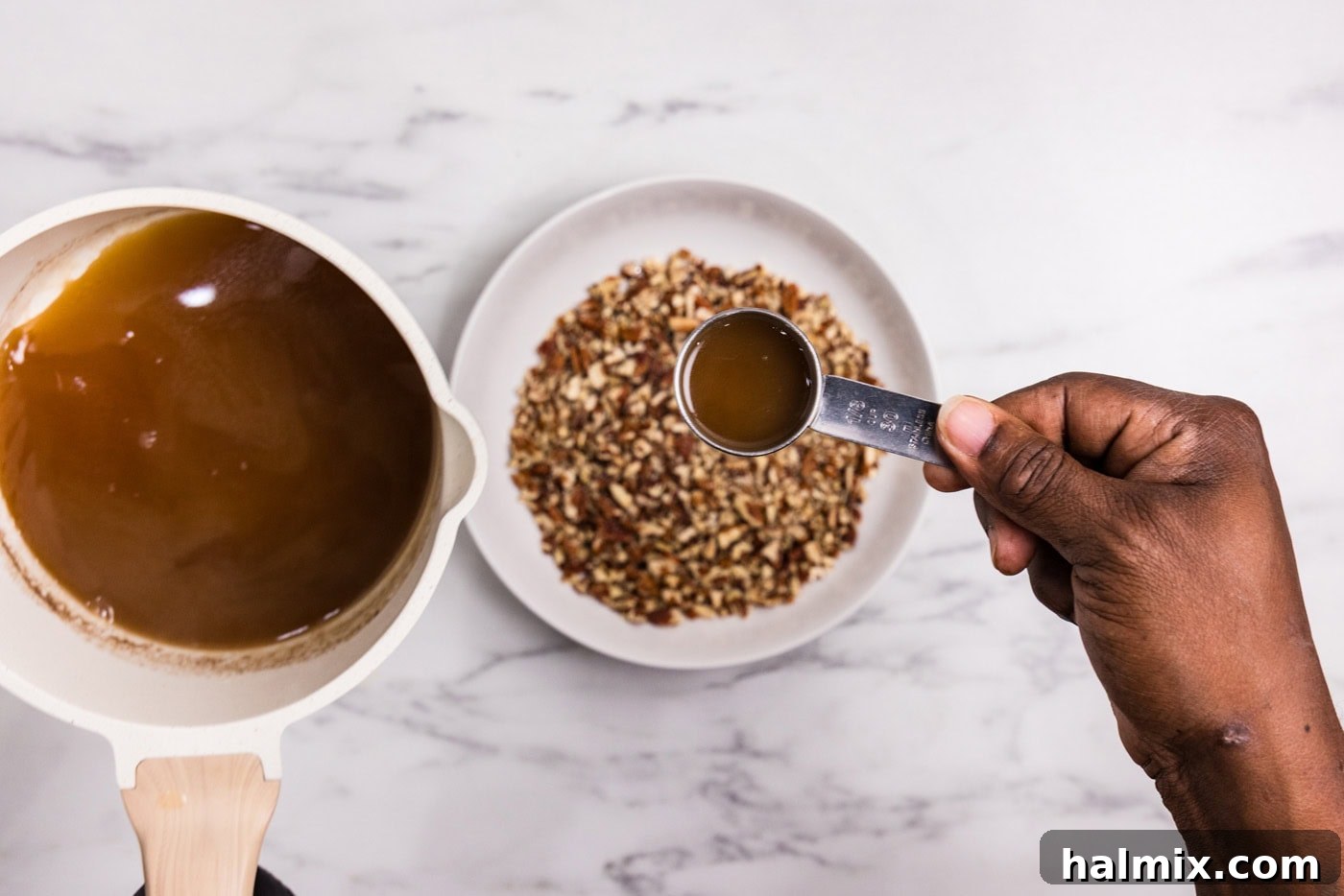 Bourbon Glazed Sweet Potatoes 9 hand adding 1/3 cup of bourbon sauce to chopped pecans