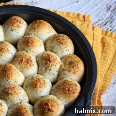 A close up photo of meatball stuffed biscuits in a cake pan.