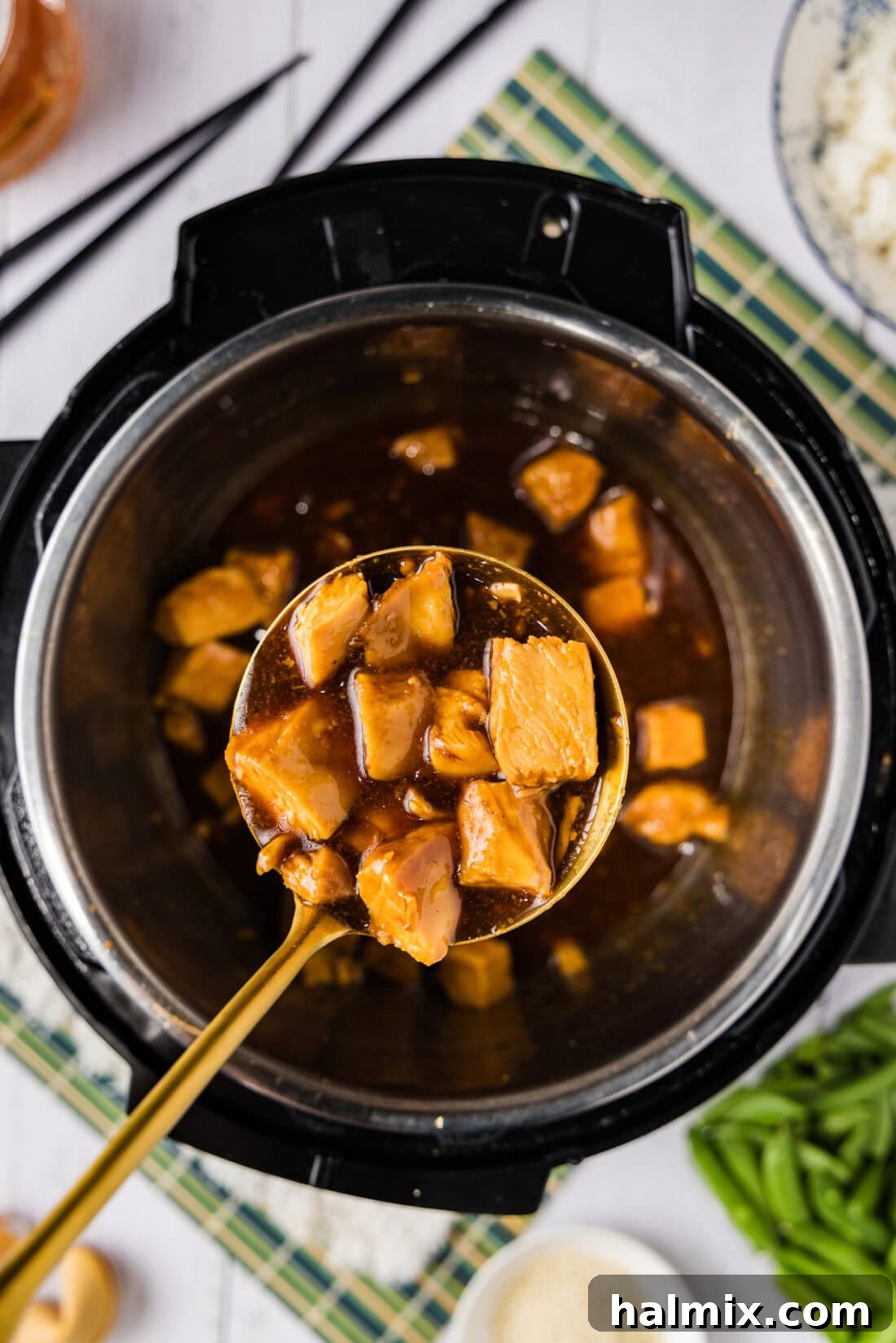 Spoonful of Instant Pot Honey Garlic Chicken held above an Instant Pot