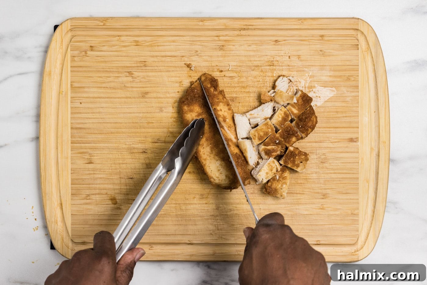 slicing chicken on a cutting board