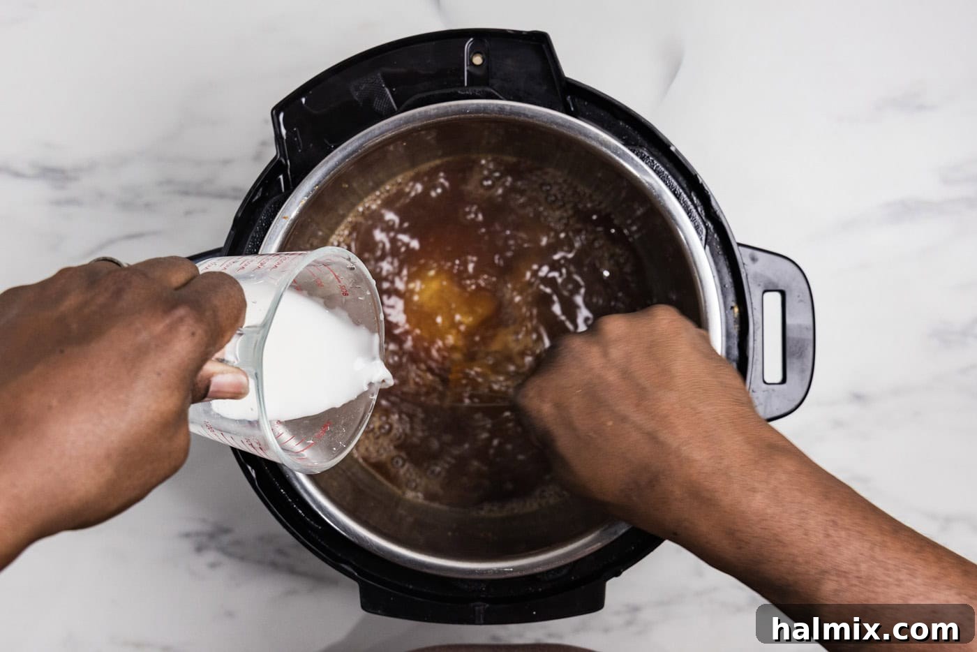 hand whisking a cornstarch slurry into honey garlic sauce