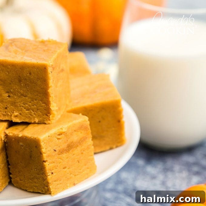 close up of pumpkin fudge squares next to a glass of milk