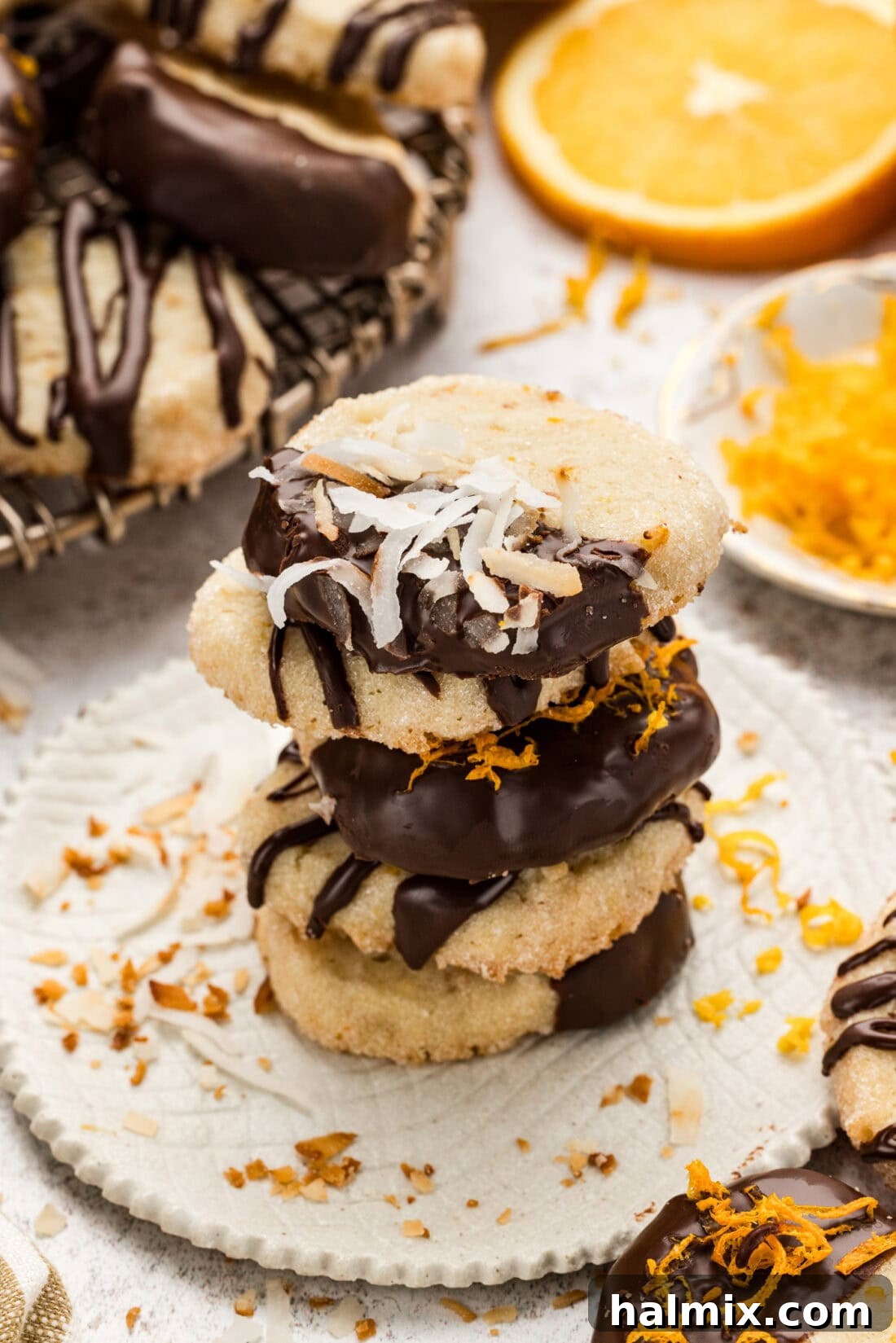 A stack of golden-brown icebox cookies, some with a chocolate dip, showcasing their soft, chewy texture.