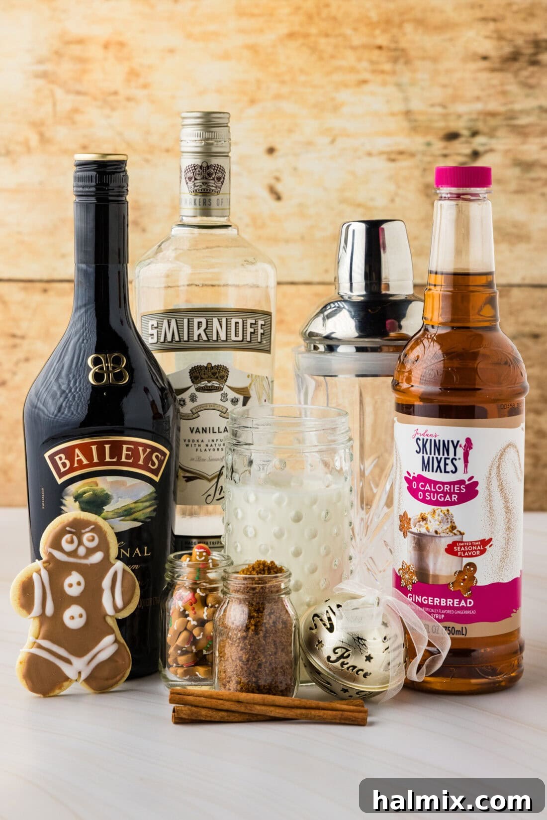 Assorted liquor bottles and holiday-themed ingredients for festive baking and cocktails, including gingerbread syrup and Irish cream.