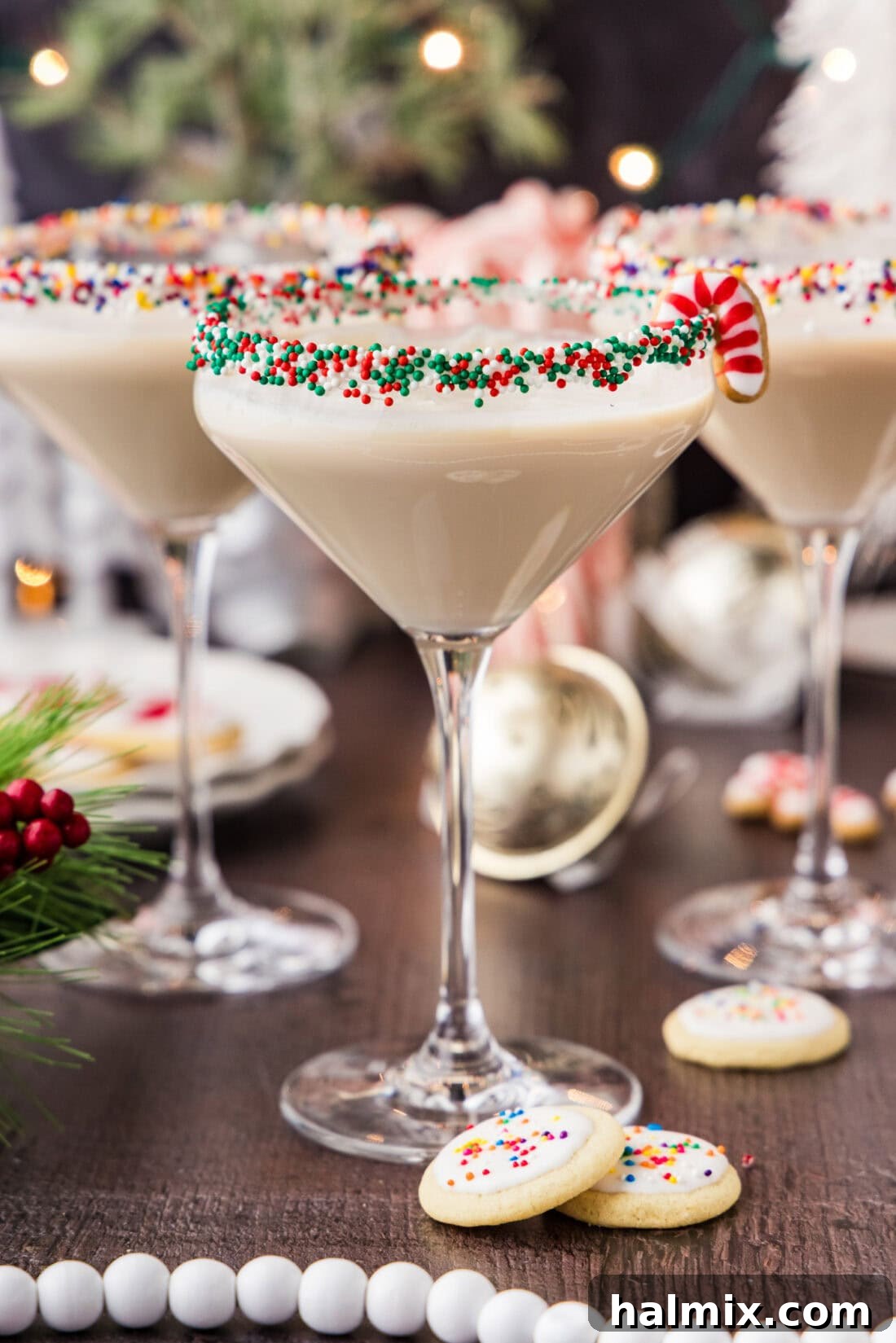 Three Sugar Cookie Martinis elegantly presented with miniature sugar cookies alongside, showcasing a festive frosted rim and a creamy texture, perfect for holiday celebrations.