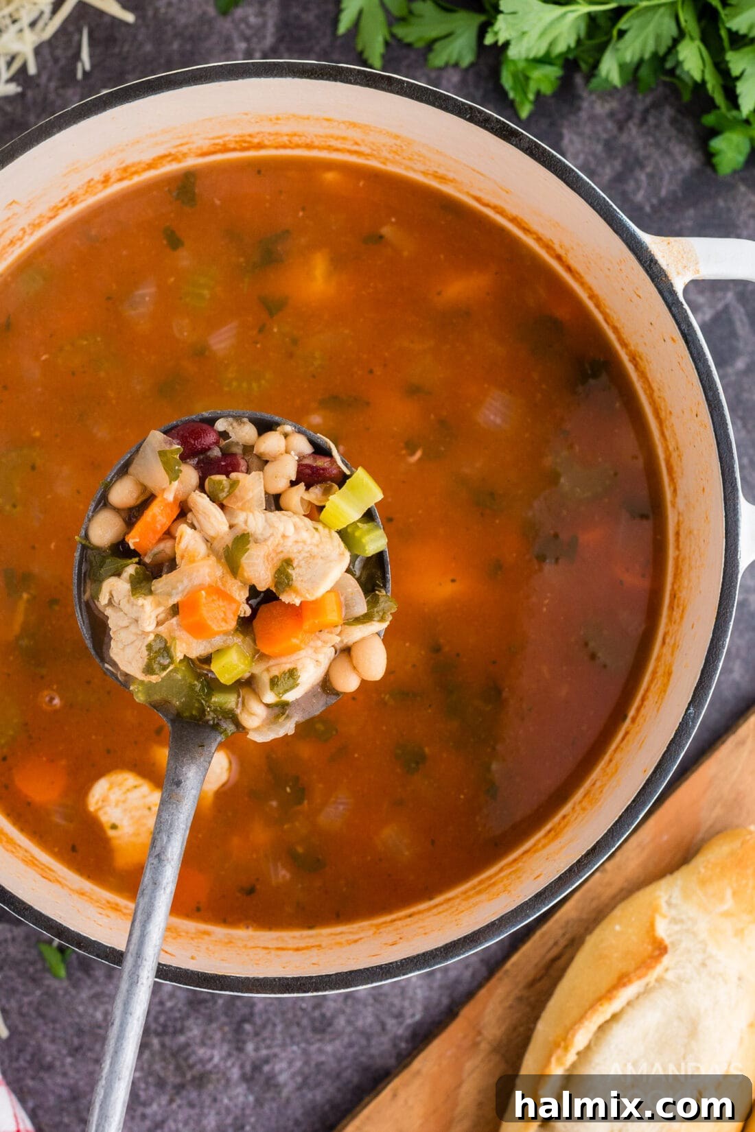 Hearty Chicken Bean Soup 2 Ladle full of rich, tomato-based chicken bean soup, garnished with fresh herbs, ready to be served in a rustic bowl.