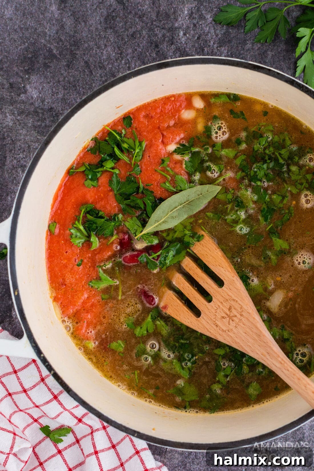 Hearty Chicken Bean Soup 3 Close-up shot of ingredients being stirred in a large Dutch oven, showcasing the cooking process of chicken bean soup.