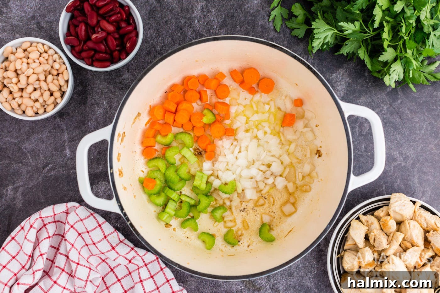 Hearty Chicken Bean Soup 6 Browning chopped onion, carrots, and celery in a Dutch oven after removing the chicken, creating an aromatic base.