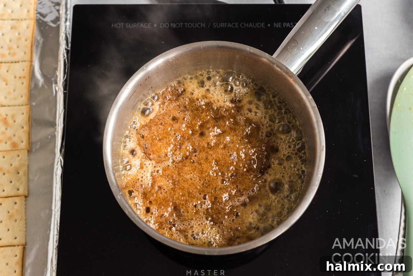 Homemade caramel boiling in a saucepan, showing its golden color