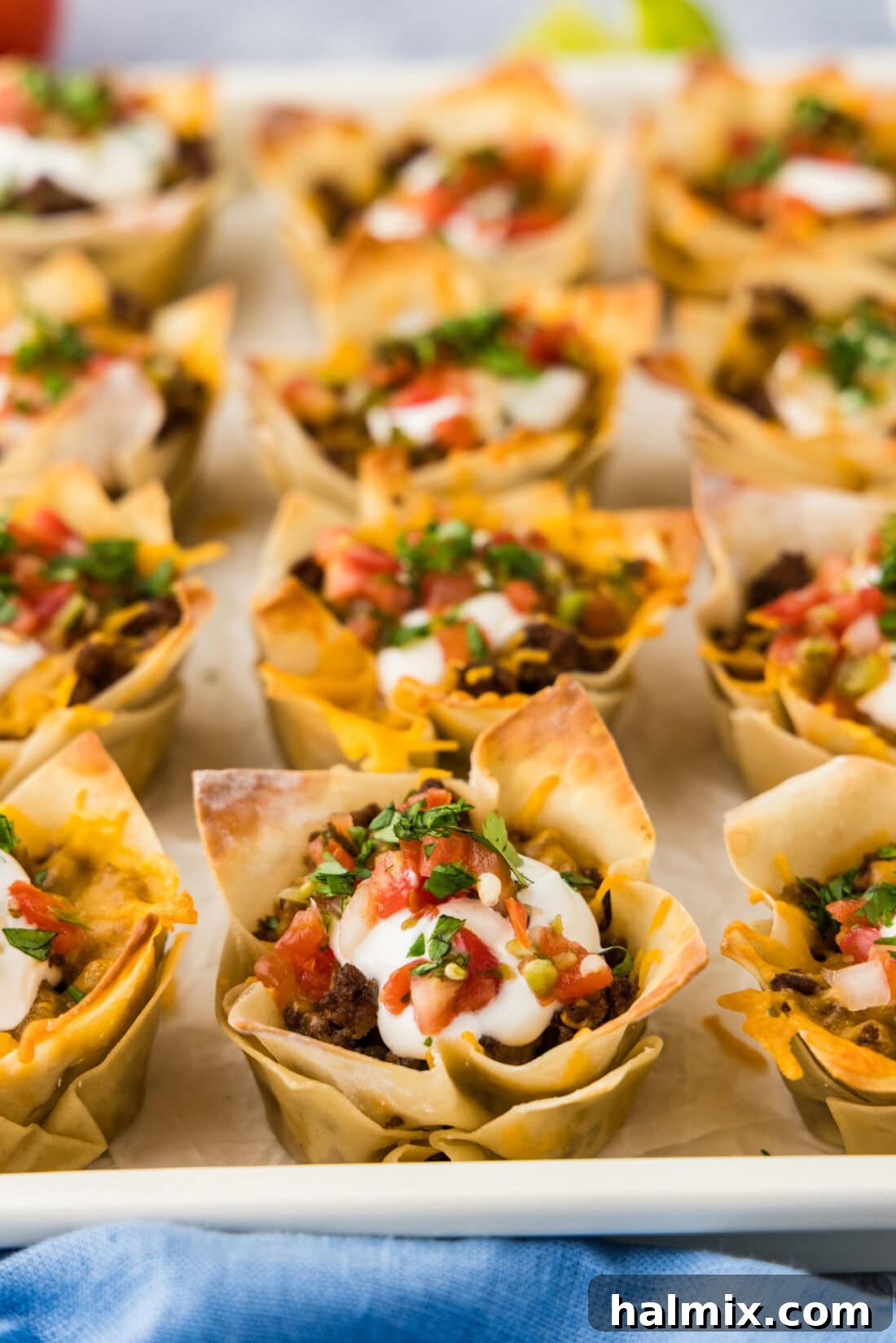 Mini Taco Bites 2 Close up photo of Taco Cups topped with sour cream and Pico de Gallo