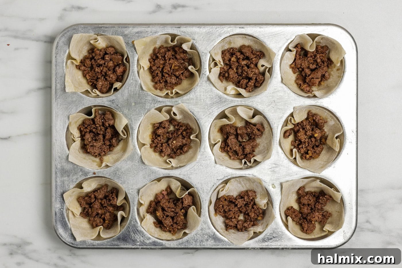 Mini Taco Bites 6 Taco meat placed inside wonton wrappers in a muffin pan