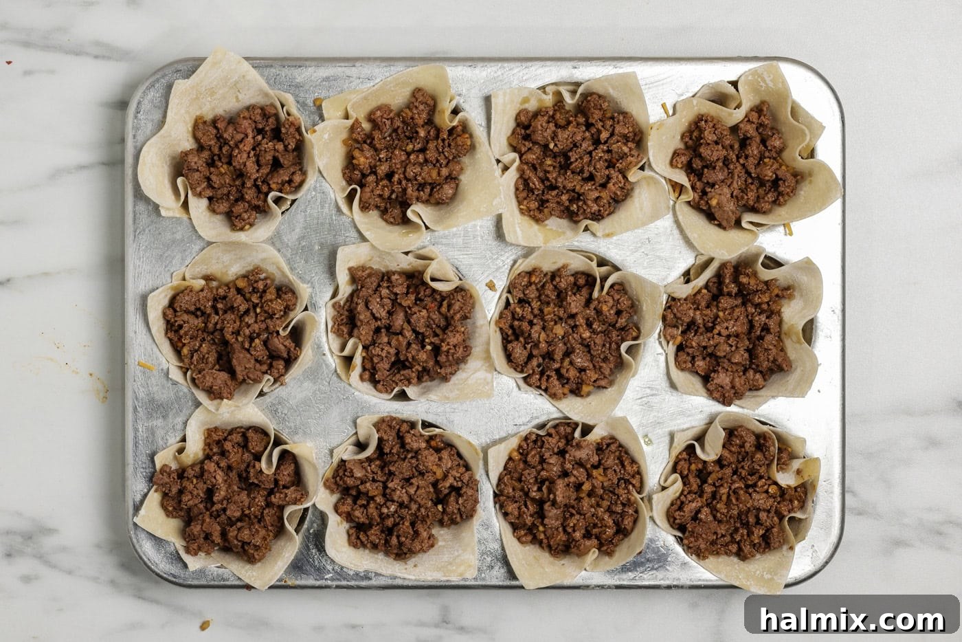 Mini Taco Bites 8 Taco meat layer overtop shredded cheese inside a wonton wrapper