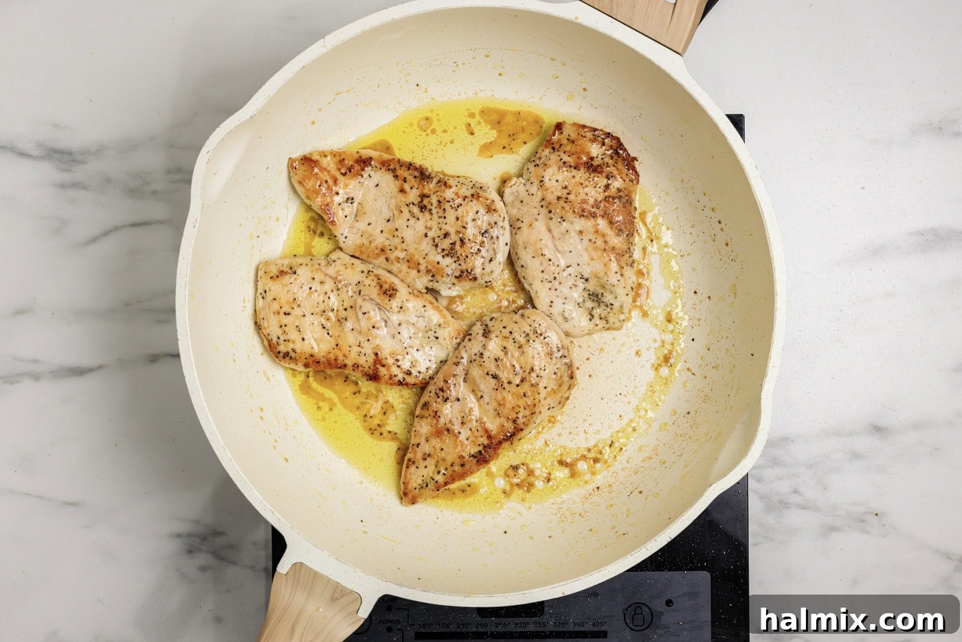 chicken breasts cooked in a skillet until golden