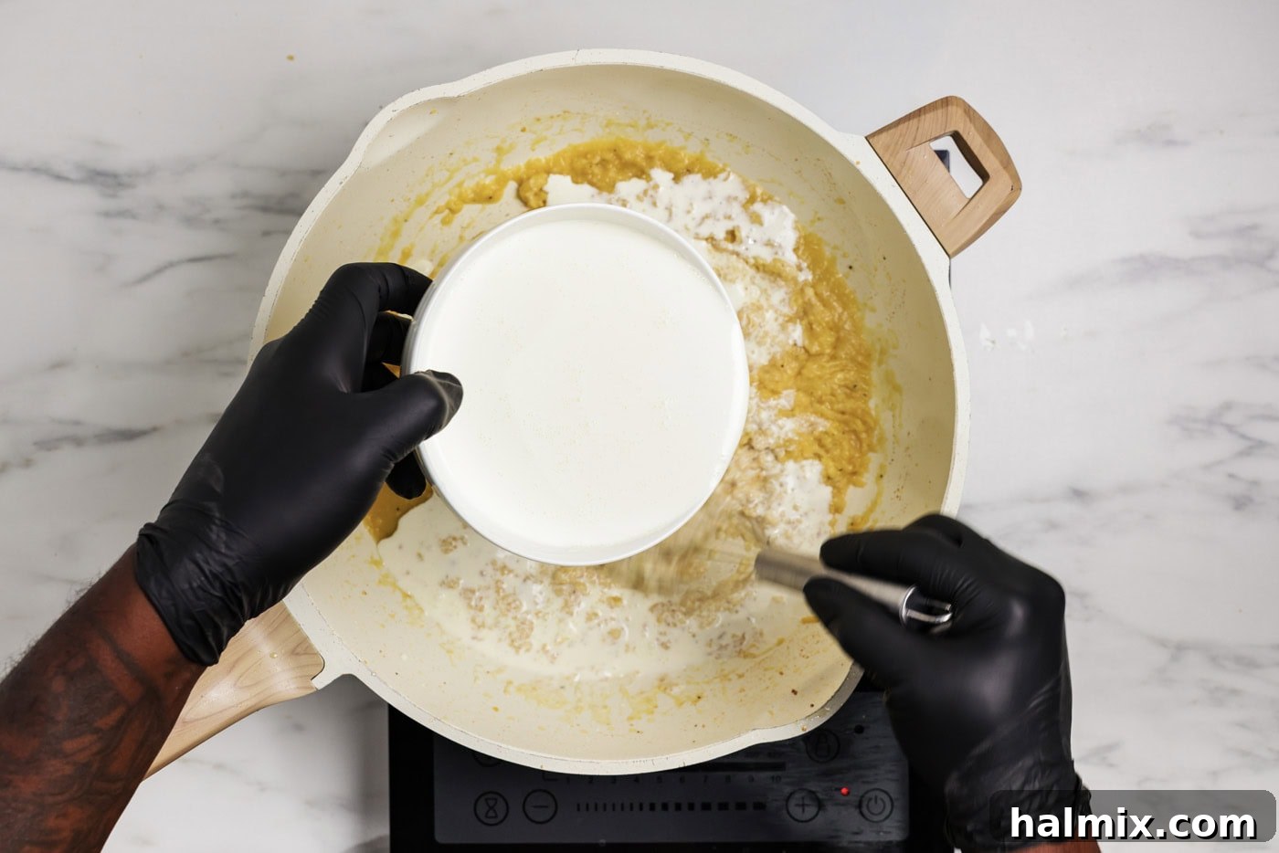 heavy cream added to skillet with a whisk