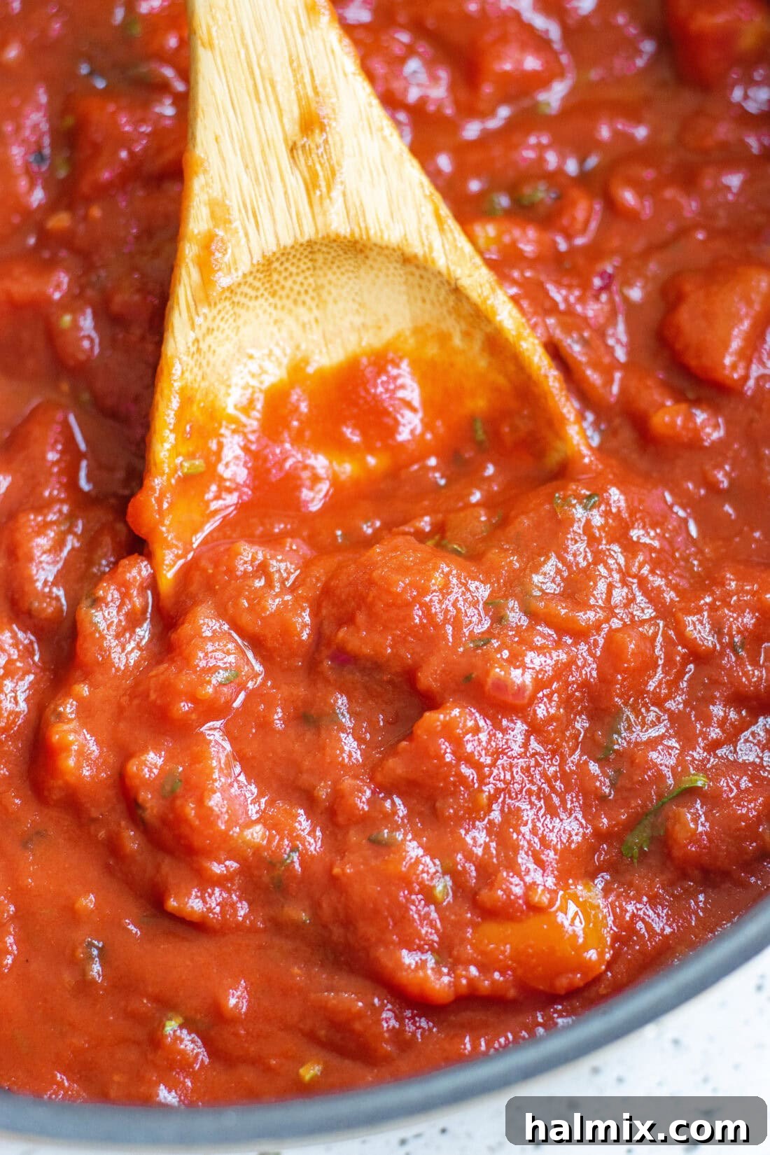 Classic Marinara Sauce 2 A close-up view of a spoonful of rich, red marinara sauce, highlighting its thick texture and hints of herbs.