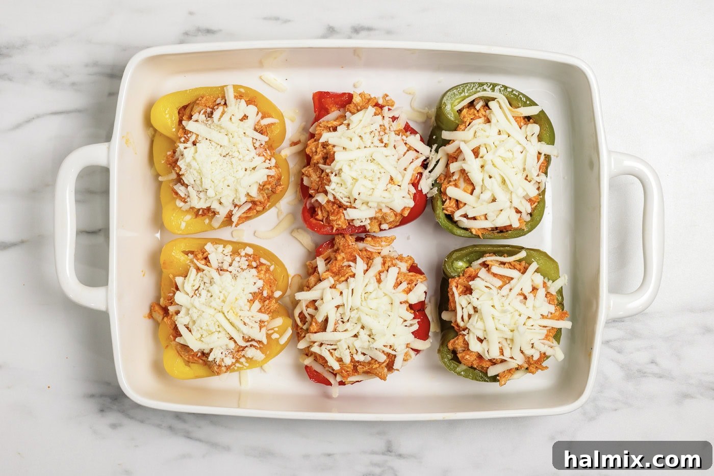 Zesty Buffalo Chicken Bell Pepper Bake 10 Mozzarella cheese on top of buffalo chicken stuffed peppers in a baking dish